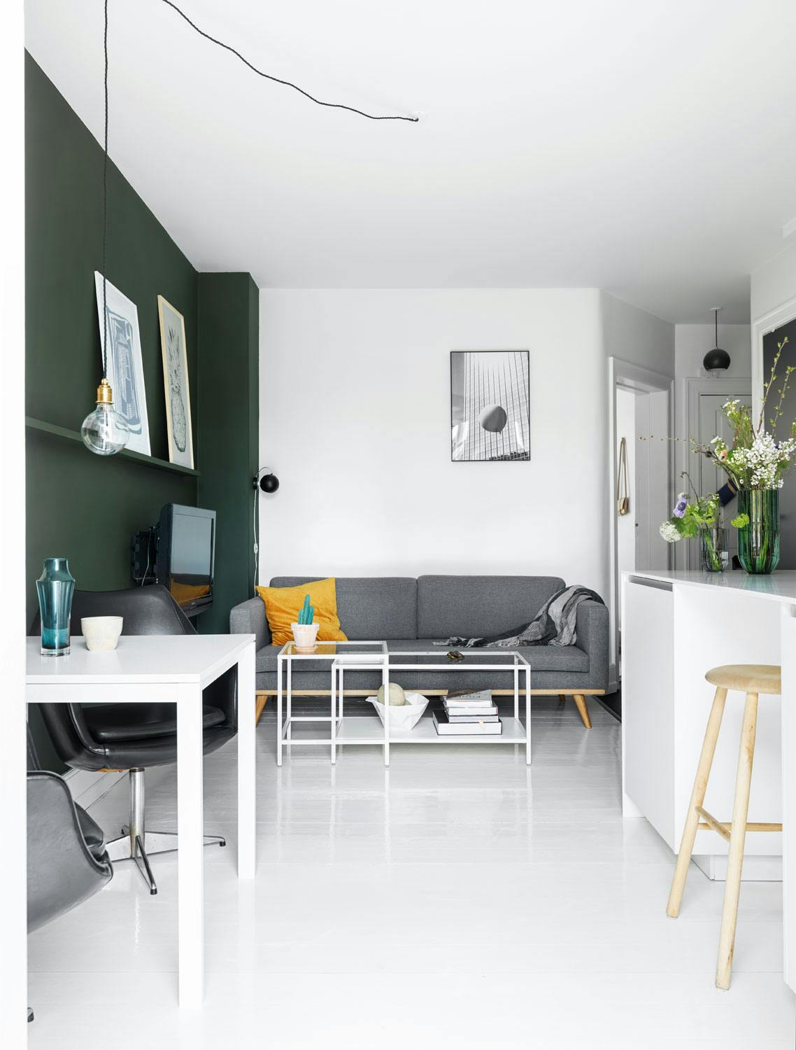 Liten, men smart stue liten stue med plass til en grå sofa i forlengelse av kjøkkenet